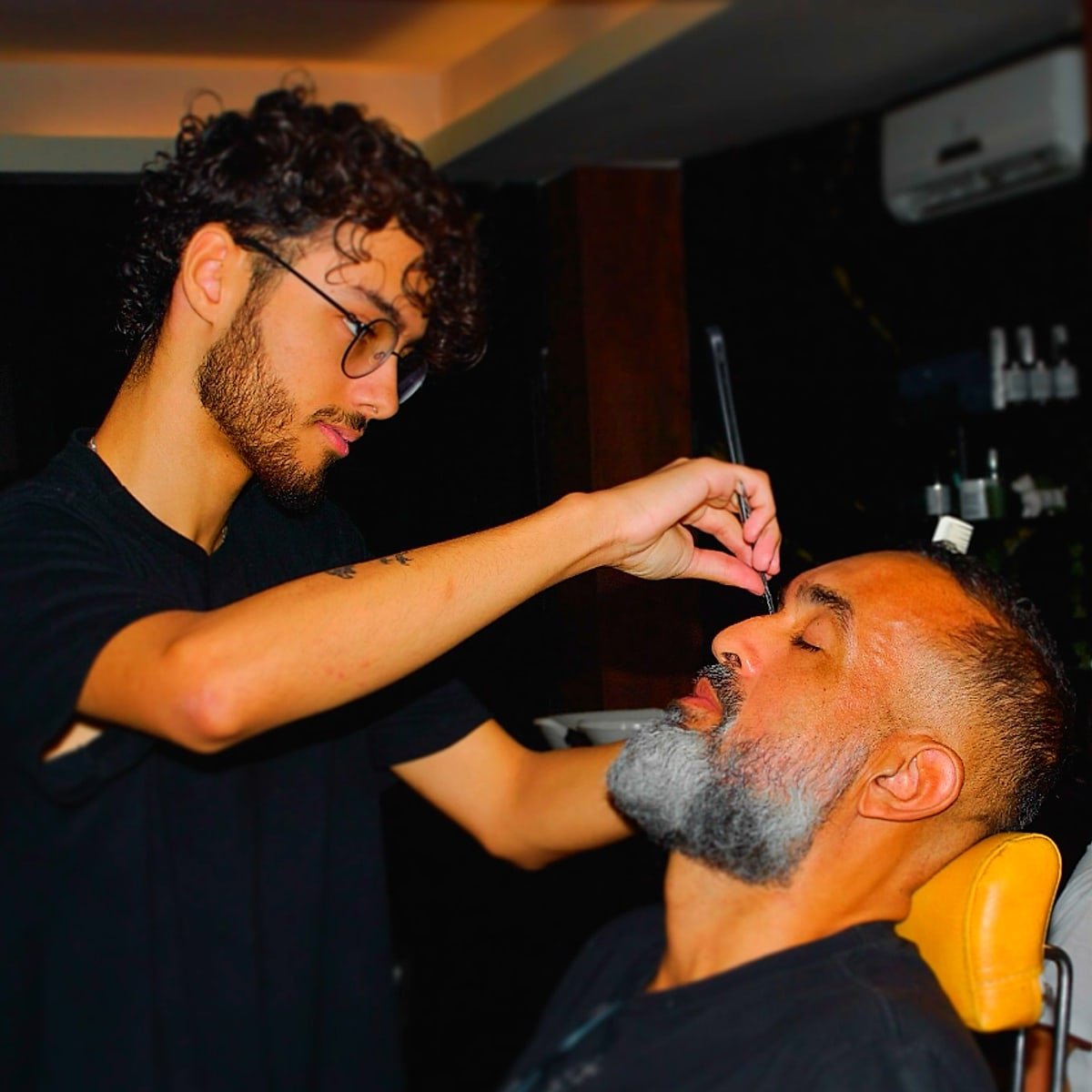 Barbeiro fazendo o acabamento de barba em cliente na Santos Barber Studio, Resende - RJ